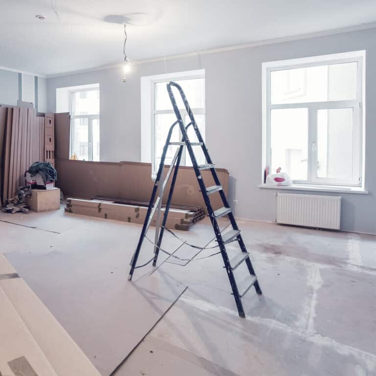 Stanza in ristrutturazione con scala e materiali edili.