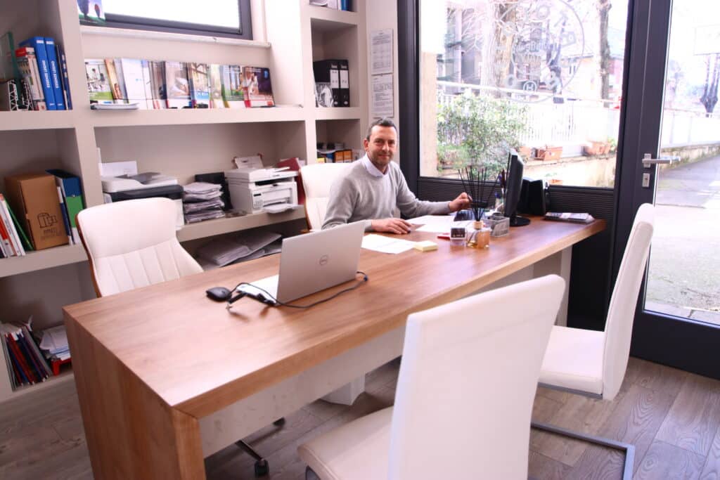 Uomo seduto alla scrivania in un ufficio luminoso.